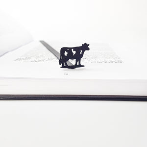 Metal cow bookmark detail shot showing cut-out spots on cow silhouette, matte black finish