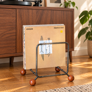 Atelier Article steel vinyl record rack with four wooden ball feet and Icehouse records on an oak floor beside a walnut turntable cabinet.