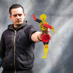 Maker holding Bauhaus circle dancer puppet at arm's length showing scale against grey background