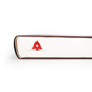 Red bonfire metal bookmark clipped between closed book pages,