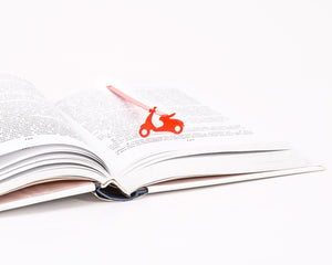 Motor Scooter metal bookmark in red lying across the pages of an open book