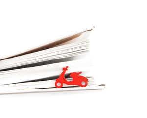 Motor Scooter metal bookmark in red resting on the pages of an open book