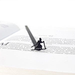 Skier in High Hat metal bookmark lying across the pages of an open book