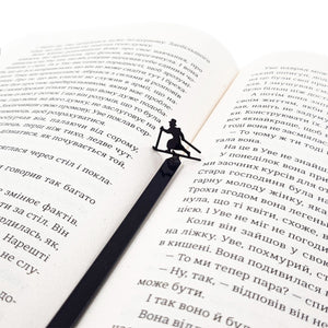 Skier in High Hat metal bookmark set into the gutter of an open book