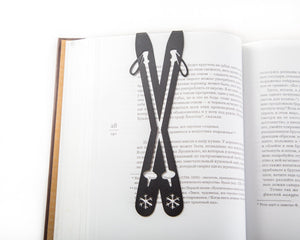 Skis metal bookmark marking a page in an open book
