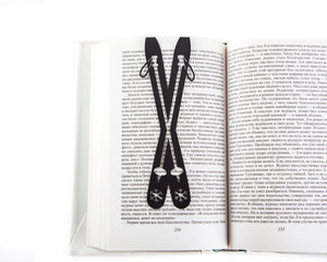 Skis metal bookmark resting on the pages of an open book
