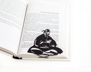 Ukrainian Kozak metal bookmark marking a page in an open book