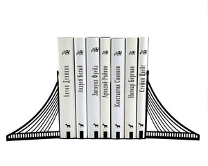 Brooklyn Bridge metal bookends holding books on a white background