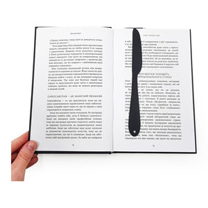 Knife-Shaped COOK metal bookmark resting on the pages of an open book