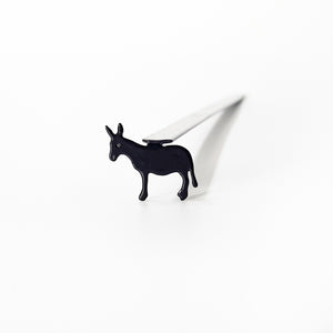 Top-down view of donkey metal bookmark inside open children's book showing scale
