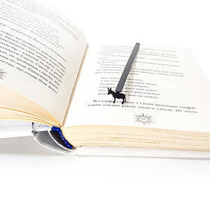 Donkey metal bookmark sitting upright inside open book with Ukrainian text pages