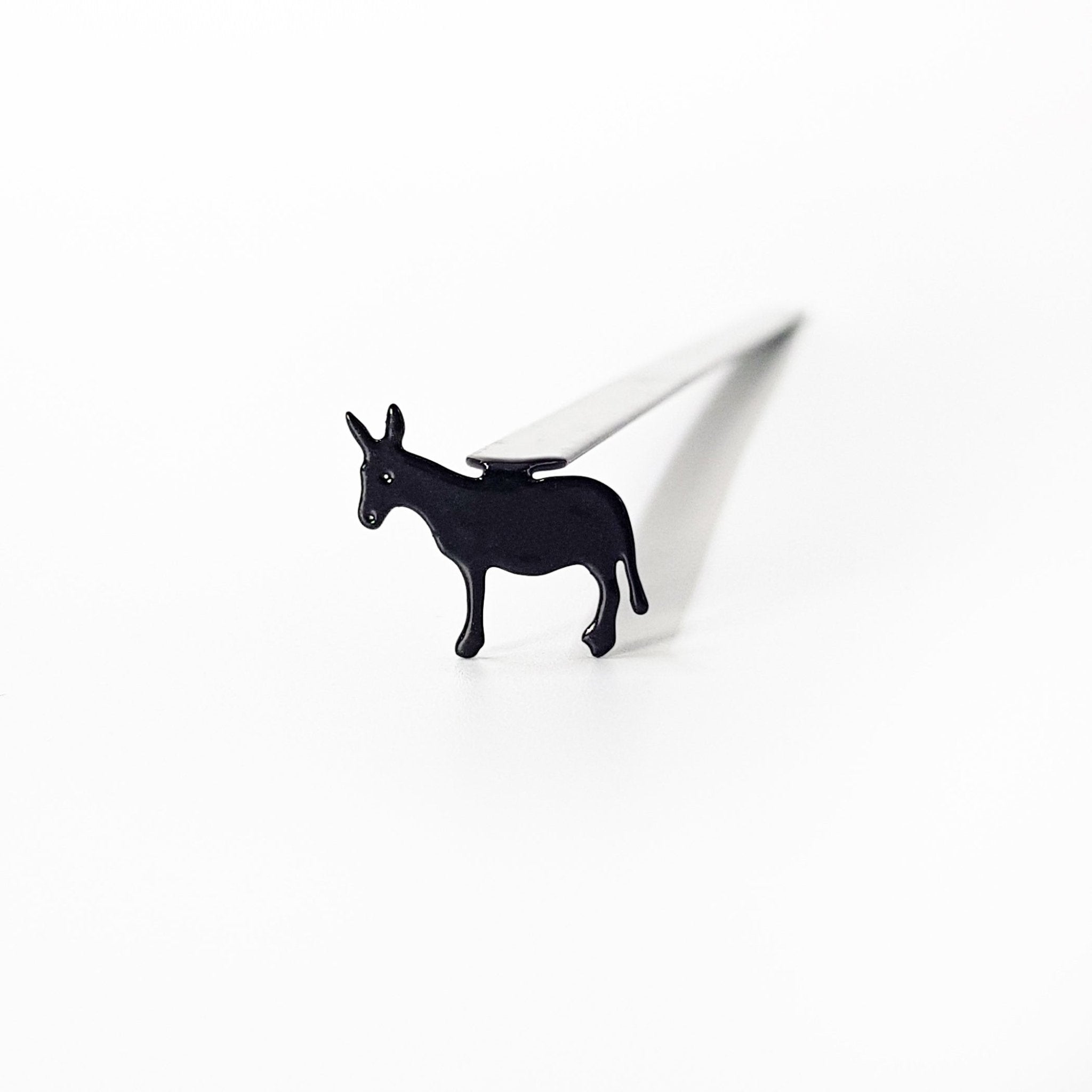 Top-down view of donkey metal bookmark inside open children's book showing scale