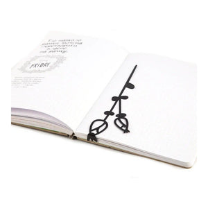 Field Flowers metal bookmark resting on the pages of an open book