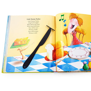 Knife-shaped COOK metal bookmark resting diagonally across an open illustrated children’s book page with colorful drawings of bread, butter, and a singing character.