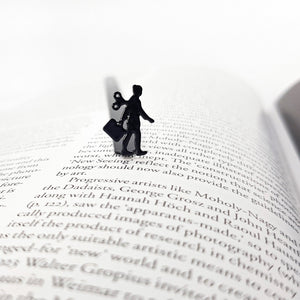 Black metal bookmark featuring a business woman silhouette resting on an open book page