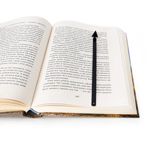 Minimalist Triangle metal bookmark marking a page in an open book