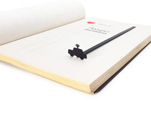 Wind-Up Toy Car metal bookmark resting on the pages of an open book