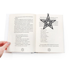 Open book with a black pentagram bookmark on a white background