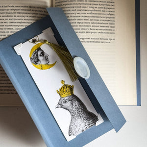 Pigeon Queen and The Moon metal bookmark on a coloured background