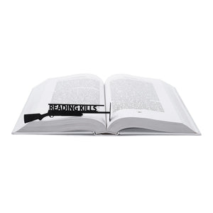 Reading Kills Stupidity metal bookmark resting on the pages of an open book