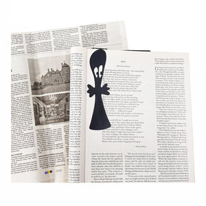 Small Ghost metal bookmark resting on the pages of an open book