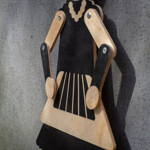 Flamenco puppet detail — black print on natural plywood grain, metal rivets and movable joints