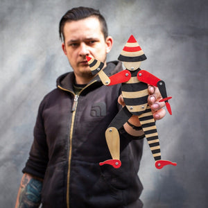 man holding handmade articulated plywood acrobat puppet showing size and movement