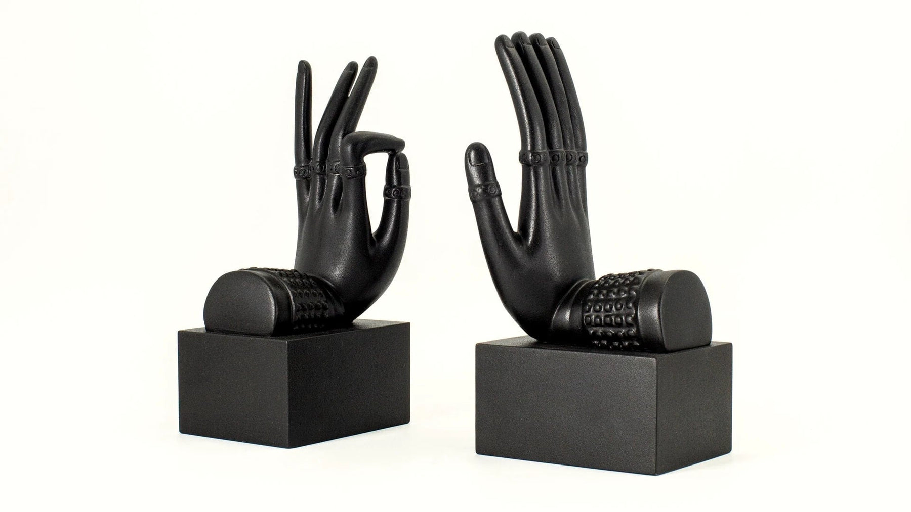 Black sculptural hand bookends on square bases.