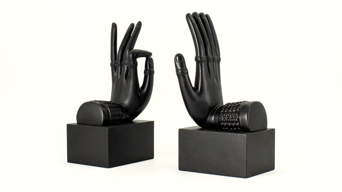 Black sculptural hand bookends on square bases.
