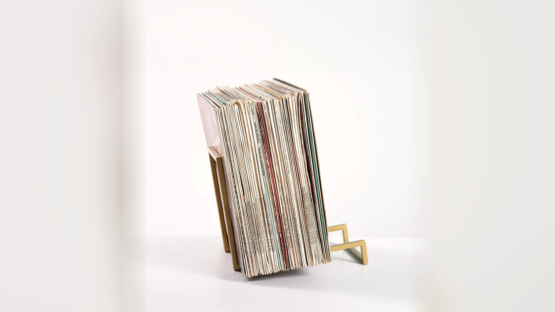 LP records standing upright and evenly supported in a steel stand.
