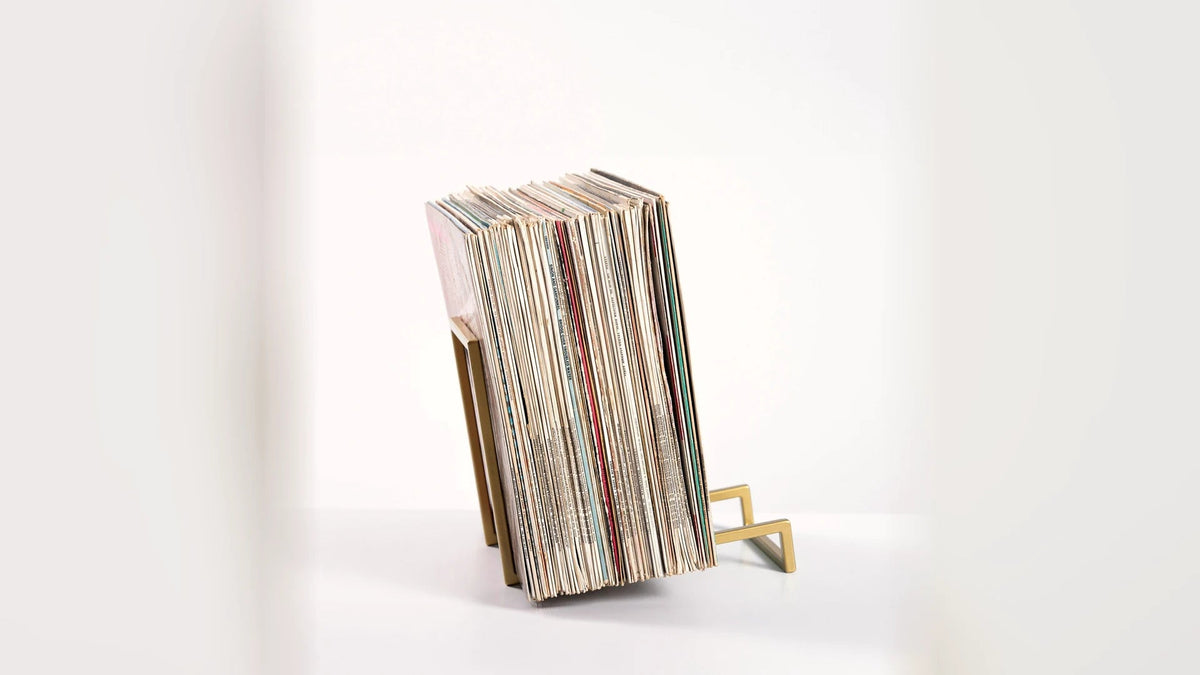 LP records standing upright and evenly supported in a steel stand.