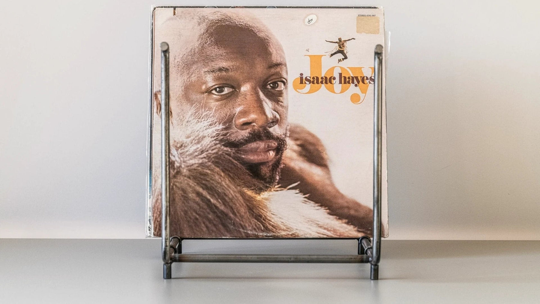 A single LP sleeve propped in an open steel frame rack.