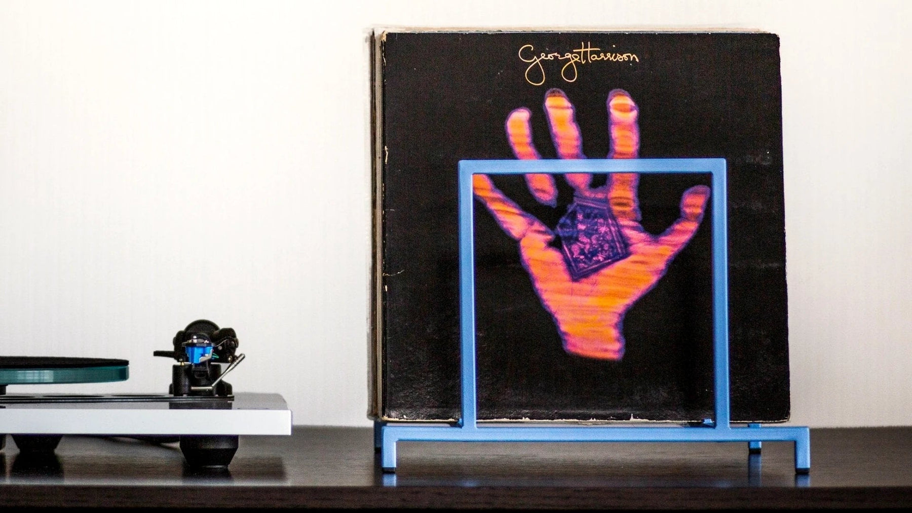 Vinyl records stored upright in a steel display stand.