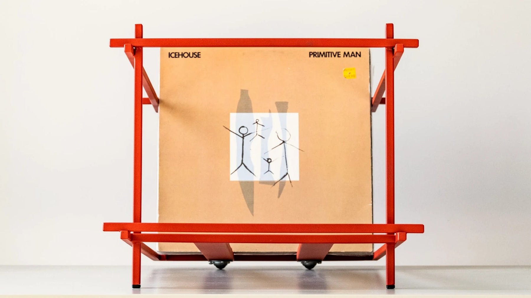 LP sleeve propped in a red steel record rack.