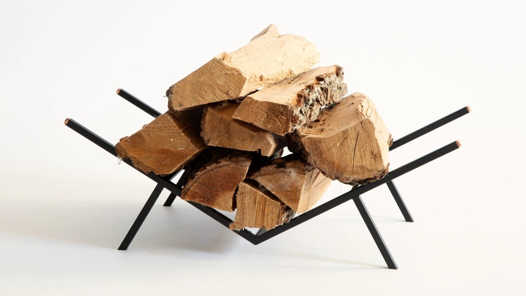 Compact copper-finish steel log holder stacked with split firewood.