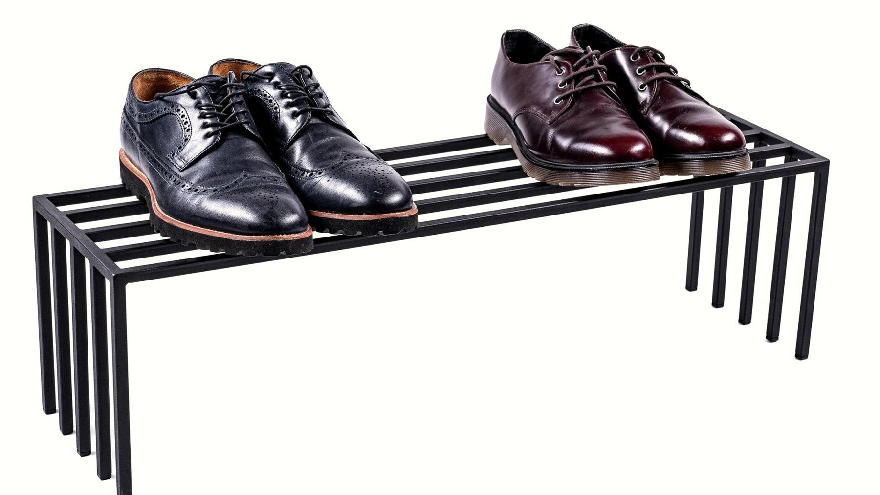 Black steel shoe rack with two pairs of leather shoes.