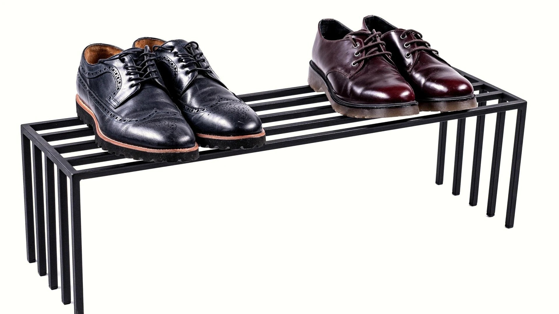 Black steel shoe rack with two pairs of leather shoes.
