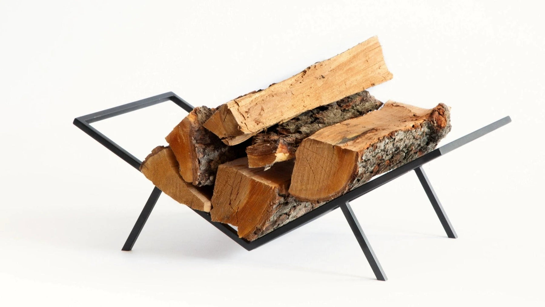 Black steel log holder cradling split birch logs.