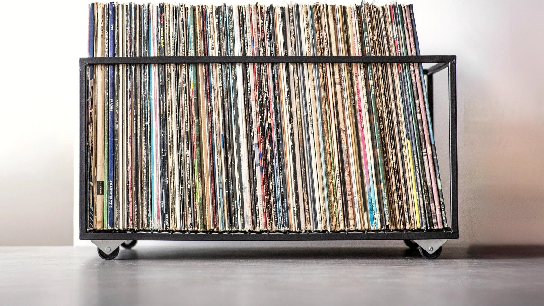 Minimalist steel crate on wheels packed with a full row of LP records.