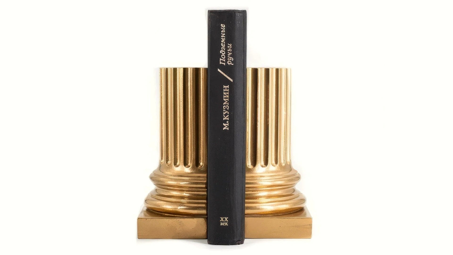 Gold neoclassical pillar bookends holding a hardcover book.