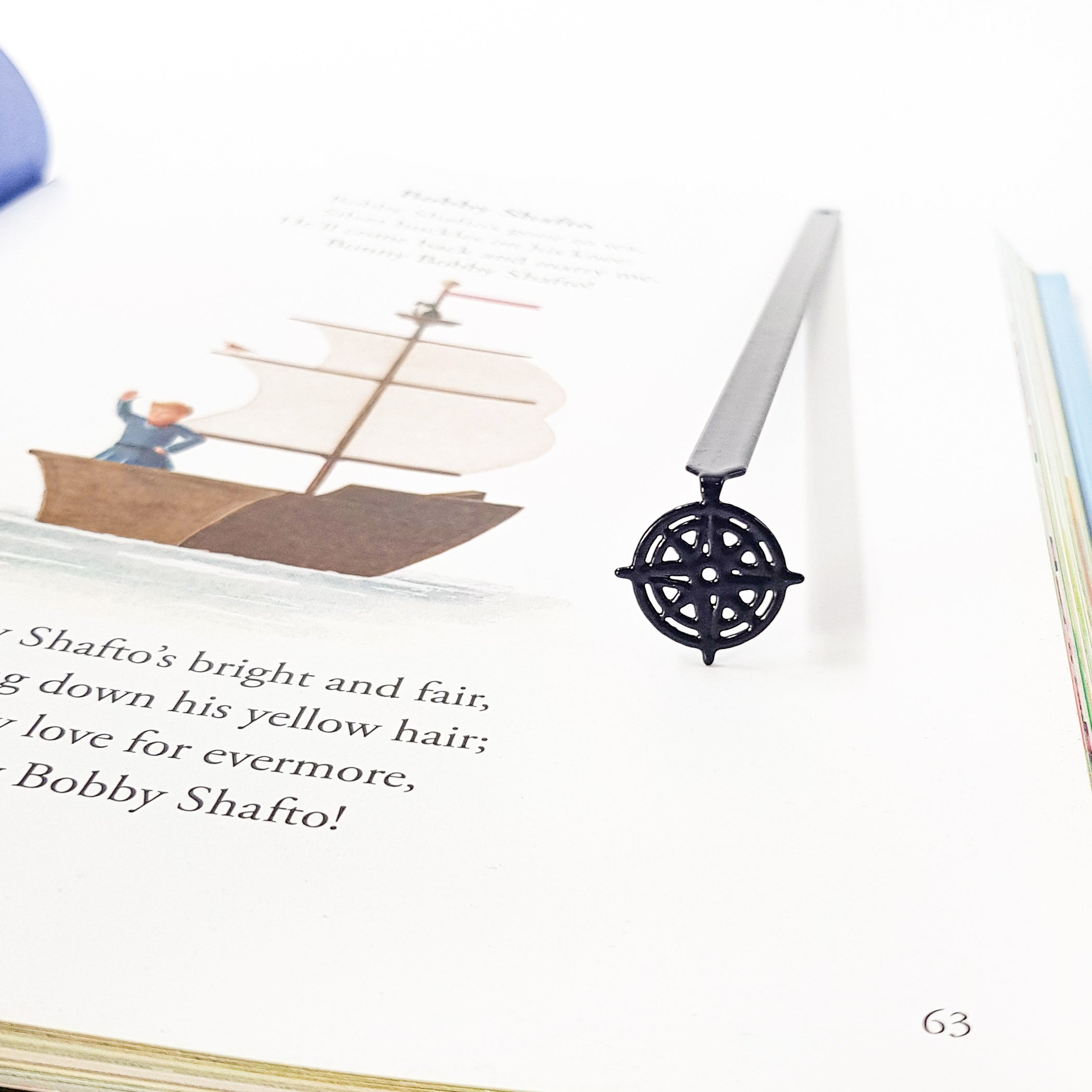 Compass rose bookmark in illustrated hardcover book, Bobby Shafto poem page with sailing ship