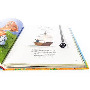 Compass rose metal bookmark tucked in open hardcover book, top-down view showing page-marking position