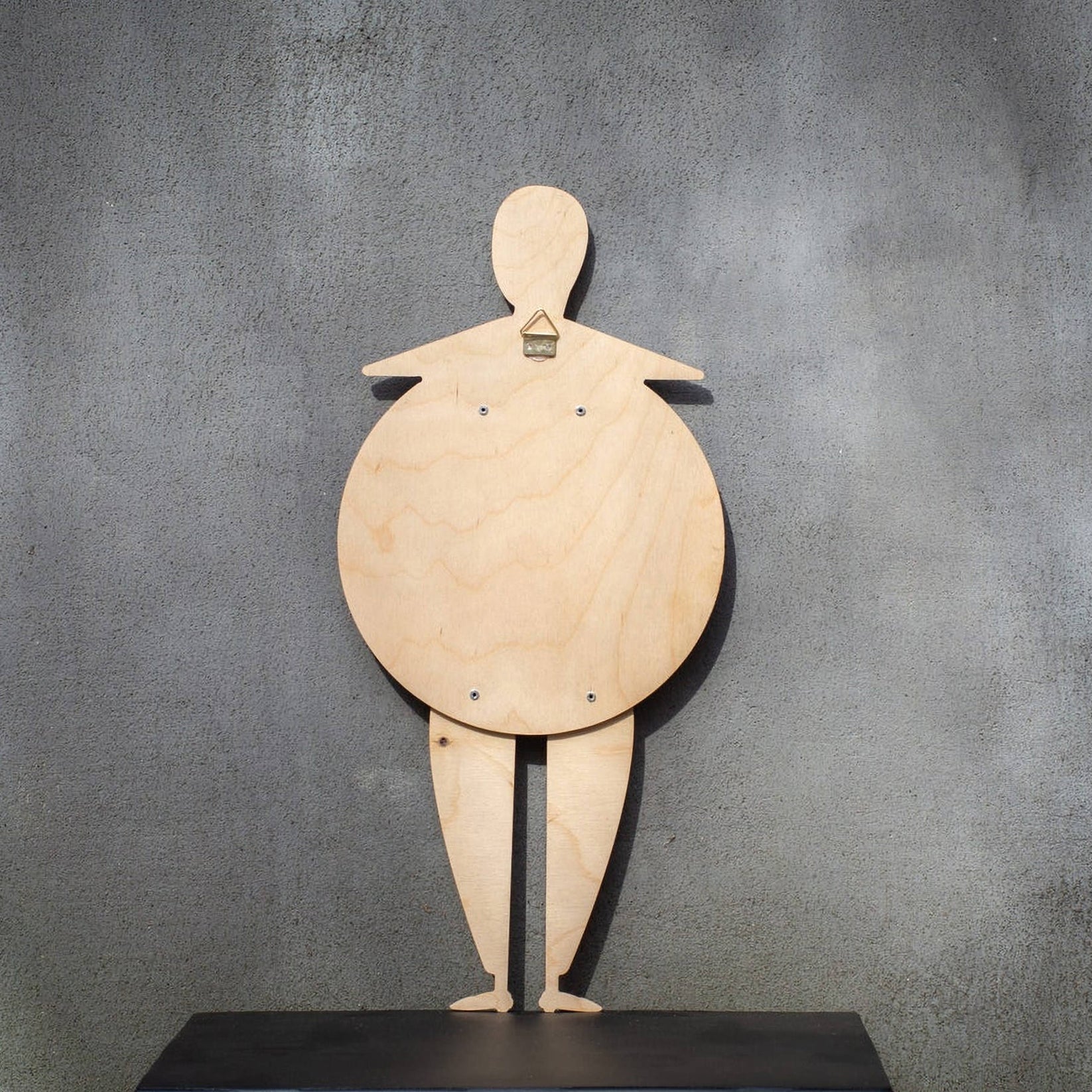 Back of the Bauhaus Beetle puppet on a shelf — natural birch plywood with wall-hanging mount