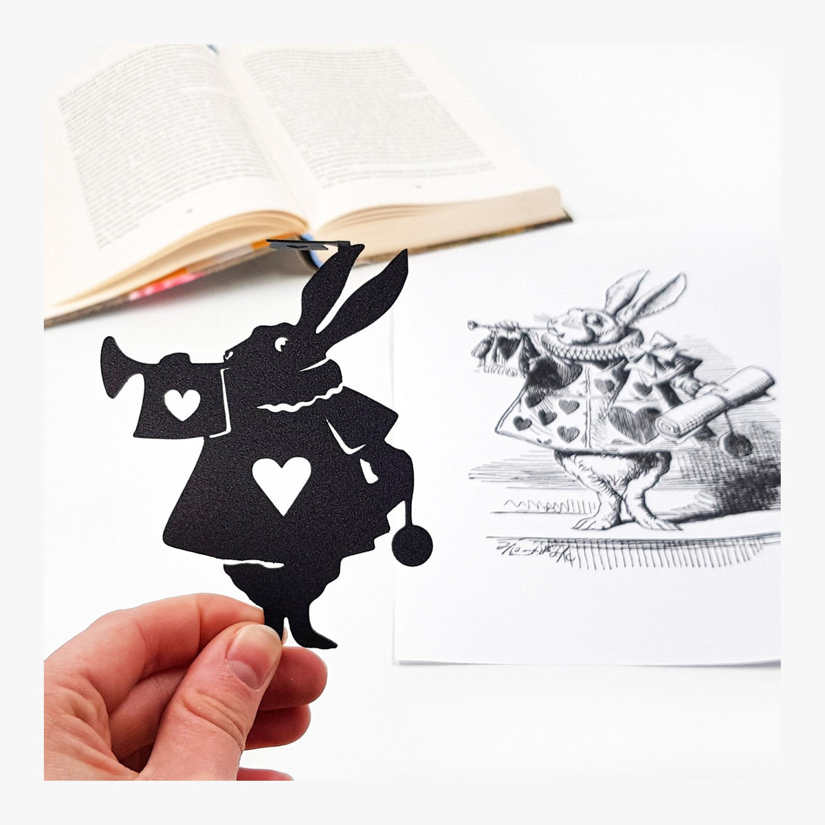 Alice in Wonderland metal bookmark marking a page in an illustrated book