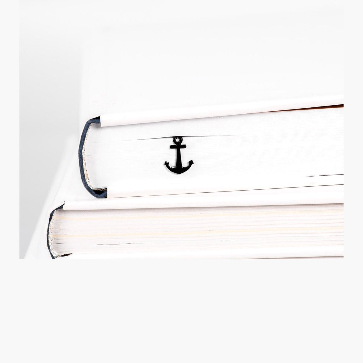 Anchor metal bookmark in a closed book, only its top showing above the pages