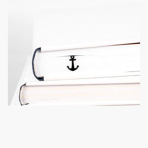 Anchor metal bookmark in a closed book, only its top showing above the pages