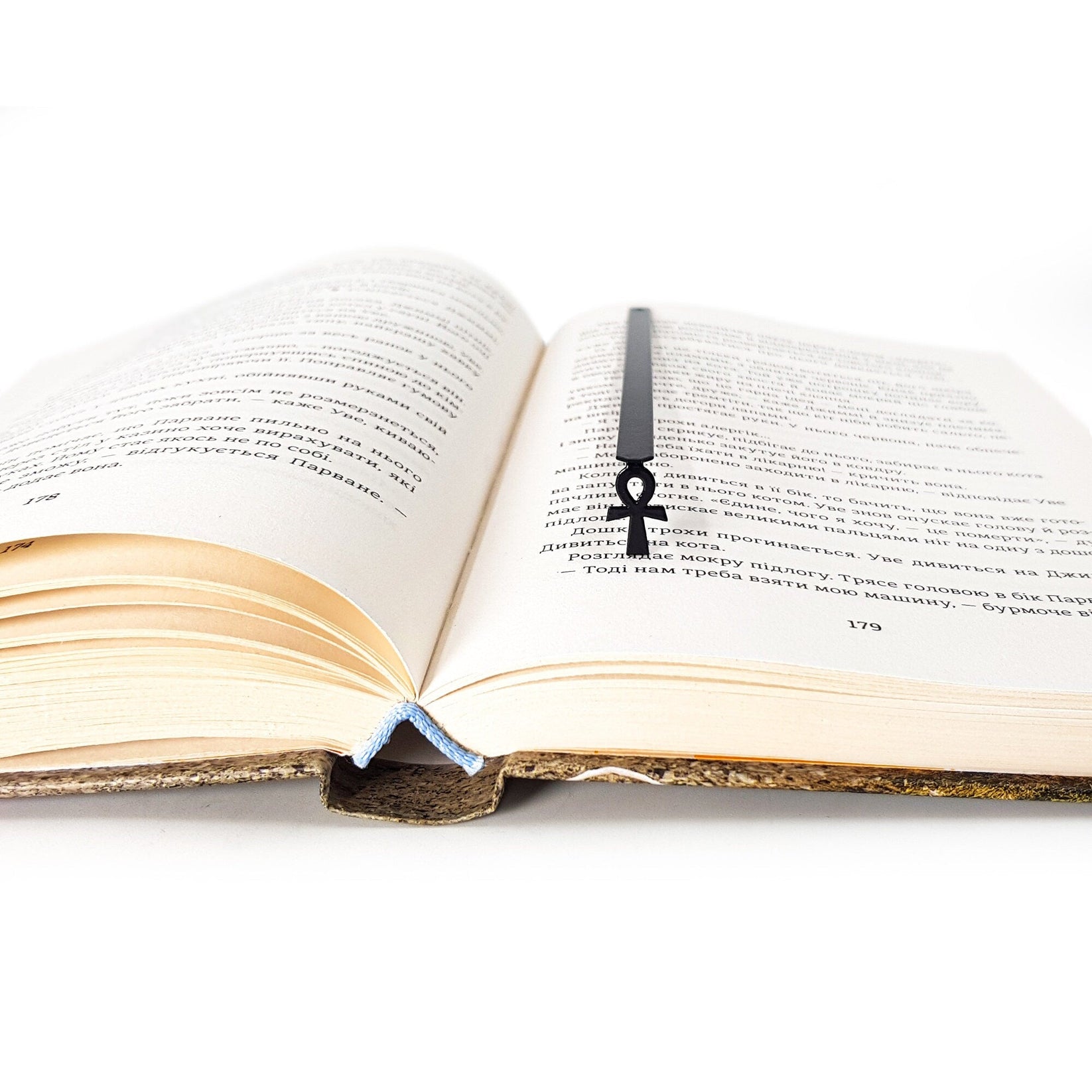 Ankh metal bookmark resting on the pages of an open book