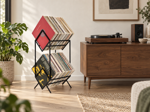 Black Atelier Article 2Romb two-tier vinyl record stand with diagonally arranged LPs beside a walnut turntable cabinet in a sunlit listening room.
