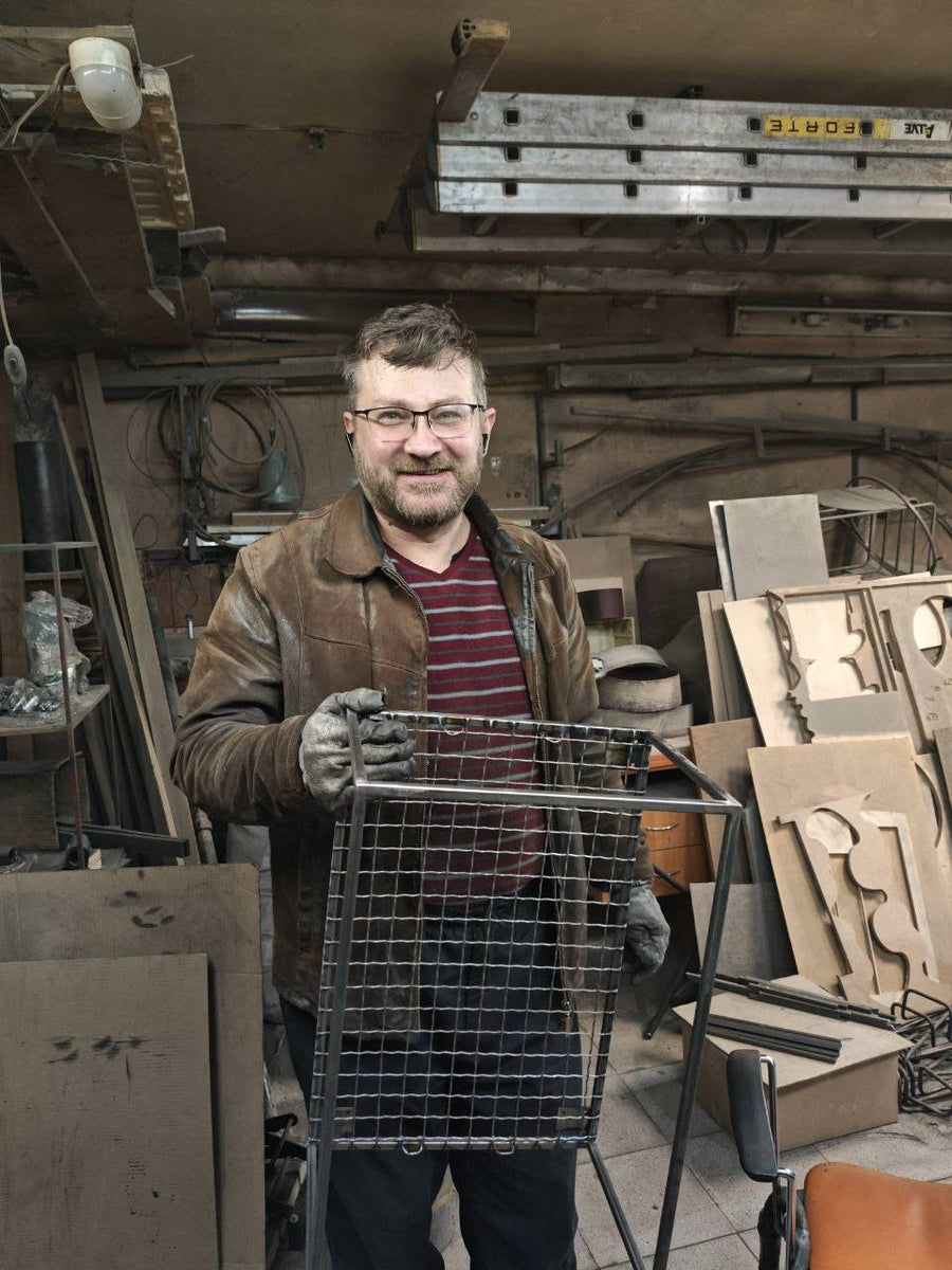 Denis of Atelier Article holding a hand-welded steel piece in the Cherkasy workshop