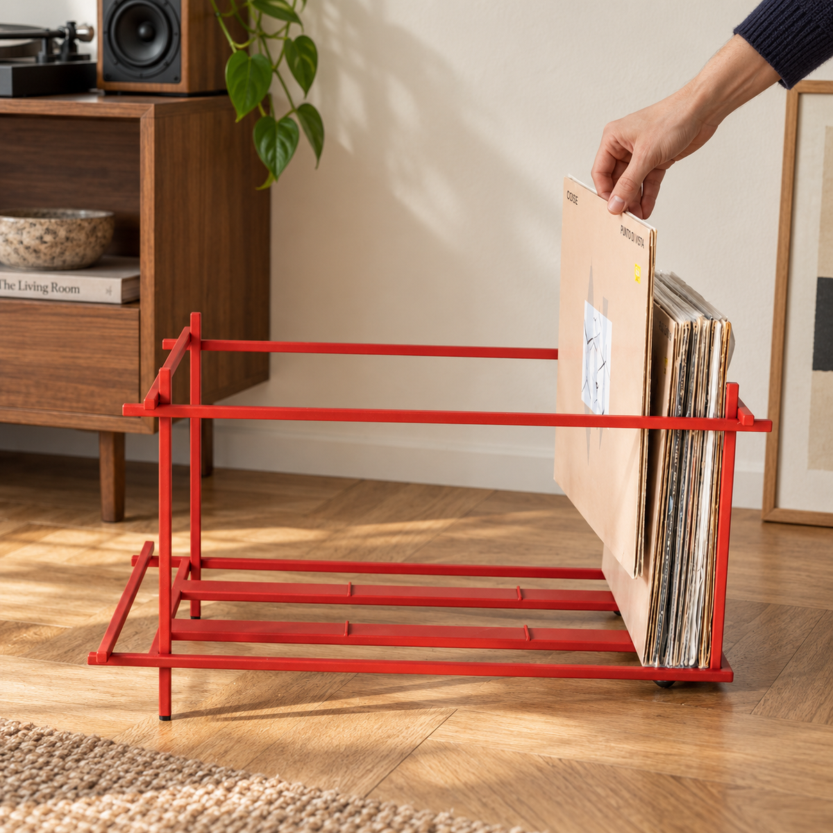 Hand selecting an LP from the Atelier Article Red Sticks red steel vinyl record crate in a listening room